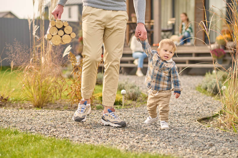 father and son walking on a pea gravel patio